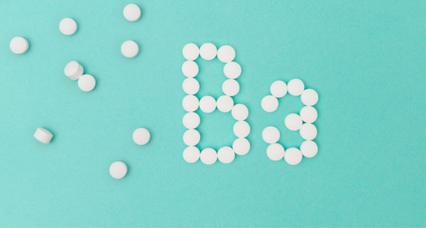 Vitamin B3 in Form von Tabletten auf türkis blauem Hintergrund